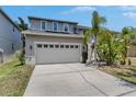 Charming two-story home with a large driveway, a two-car garage, and lush tropical landscaping at 10636 Dawns Light Dr, Riverview, FL 33578