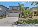Attractive two-story home boasting a spacious driveway, attached two-car garage, and verdant tropical landscaping at 10636 Dawns Light Dr, Riverview, FL 33578