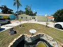 Landscaped front yard featuring a decorative fountain, palm tree, and well-maintained lawn at 1101 Alcazar S Way, St Petersburg, FL 33705