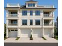 Stunning three-story townhome with multiple balconies and three garage doors at 1104 Pass A Grille Way, St Pete Beach, FL 33706