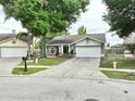 Charming single-story home with a well-manicured lawn, a two-car garage, and a welcoming front porch area at 11314 Silverleaf Ct, Riverview, FL 33579