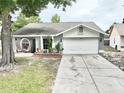 Charming single-story home with a well-manicured lawn, a two-car garage, and a welcoming front porch area at 11314 Silverleaf Ct, Riverview, FL 33579