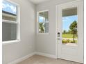 Bright foyer featuring tile floors and a view of the landscaped front yard through the glass front door at 11359 Boundless Ter, Venice, FL 34293