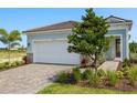 Two-car garage with patterned driveway and manicured landscaping on a sunny day at 11375 Boundless Ter, Venice, FL 34293