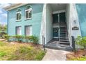 Exterior of building with teal paint, an exterior staircase, a wreath, and lush greenery and landscaping at 11404 2Nd N St # 3, St Petersburg, FL 33701