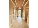 Grand foyer featuring tile floors, wainscoting, and a statement chandelier at 11489 Bitola Dr, Odessa, FL 33556