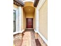 Inviting front entryway with arched alcove, decorative stone accents, and a solid wood door with sidelights at 11489 Bitola Dr, Odessa, FL 33556