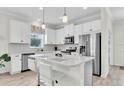 Modern kitchen featuring white cabinetry, stainless steel appliances, an island, and sleek countertops at 11626 Blue Woods Dr, Riverview, FL 33569