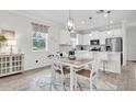 Bright eat-in kitchen with white cabinets, stainless steel appliances, and pendant lighting at 11626 Blue Woods Dr, Riverview, FL 33569