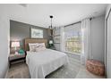 Comfortable bedroom with a stylish light fixture, wicker accents, and bright natural light at 118 Leisure Pl, Rotonda West, FL 33947