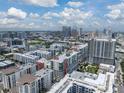 Aerial view of a cityscape with multiple condo buildings, highways, and skyscrapers against a partly cloudy sky at 1208 E Kennedy Blvd # 914, Tampa, FL 33602