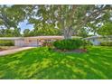 Charming single-story home with a lush green lawn, mature trees, and a cozy, inviting exterior at 1500 Robinson N Dr, St Petersburg, FL 33710