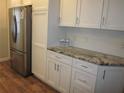 Bright kitchen features stainless steel appliances, granite countertops, white cabinets, and hardwood flooring at 162 Sw Lincoln N Cir, St Petersburg, FL 33703