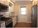 Modern kitchen with stainless steel appliances, granite countertops, white cabinets and hardwood flooring at 162 Sw Lincoln N Cir, St Petersburg, FL 33703