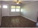 Well lit, spacious living room with hardwood floors, a ceiling fan, and a large window for natural light at 162 Sw Lincoln N Cir, St Petersburg, FL 33703