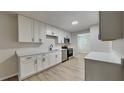 Modern kitchen with white cabinets, stainless steel appliances and hardwood floors at 2105 Oakview Ln, Plant City, FL 33566