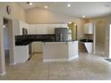 Open kitchen with white cabinets, stainless steel appliances, and black countertops at 2213 Towering Oaks Cir, Seffner, FL 33584