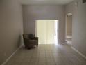 Bright living room with tiled floor, featuring an armchair and sliding glass door at 2213 Towering Oaks Cir, Seffner, FL 33584