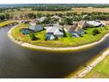 Aerial view of homes surrounding a lake, each with a screened-in pool at 2908 122Nd Pl E, Parrish, FL 34219