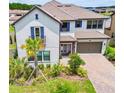 Elegant two-story home with tile roof, paver driveway, blue shutters and beautifully landscaped front yard at 29895 Picana Ln, Wesley Chapel, FL 33543