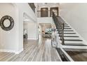 Grand foyer with soaring ceilings, stylish staircase, and elegant wood-look tile flooring at 29895 Picana Ln, Wesley Chapel, FL 33543