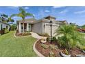 Charming single-Gathering home featuring a well-manicured lawn, landscaped garden beds, and a two-car garage at 3603 Woodmont Dr, Parrish, FL 34219