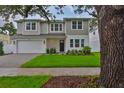 Attractive two-story home with manicured lawn, a brick driveway and neat front yard landscaping at 3614 W Platt St, Tampa, FL 33609