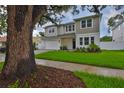 Two-story home with manicured lawn, a brick driveway, tidy front landscaping and neutral color palette at 3614 W Platt St, Tampa, FL 33609