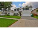 Charming two-story home boasts a well-manicured lawn, dark shutters, and an attached two-car garage at 3616 W Platt St, Tampa, FL 33609