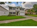 Charming two-story home boasts a well-manicured lawn, dark shutters, and an attached two-car garage at 3616 W Platt St, Tampa, FL 33609