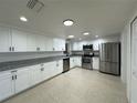 Modern kitchen featuring stainless steel appliances, white cabinets, and granite countertops at 4322 Baden Dr, Holiday, FL 34691