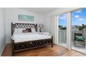 Bright bedroom featuring a decorative bamboo bed frame and a sliding glass door with balcony at 623 Garland Cir, Indian Rocks Beach, FL 33785