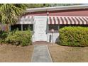 Charming entryway with a unique door and awning, surrounded by lush green bushes at 6427 15Th N St, St Petersburg, FL 33702