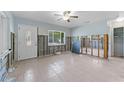Spacious room featuring ceramic floors, a ceiling fan, and an exterior door at 6750 Hibiscus S Ave, South Pasadena, FL 33707