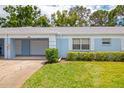 Single-story home with a one-car garage, blue paint, and well-maintained landscaping at 8064 Brentwood Rd, Seminole, FL 33777