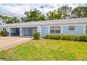 Single-story home with a well-manicured lawn, blue paint, and a one-car garage at 8064 Brentwood Rd, Seminole, FL 33777