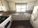 Bright kitchen featuring white cabinets, stainless steel appliances, and a window for natural light at 10208 Oak Hill Dr, Port Richey, FL 34668