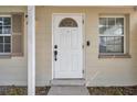 Close-up of the front door, featuring a secure lock system, a peephole, and a half-moon window above at 10381 108Th Ave, Largo, FL 33773