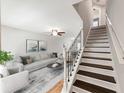 Bright living room features an open floor plan and wood staircase with white risers and decorative metal railings at 10436 Rivercrest Dr, Riverview, FL 33578