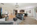 Open concept living room with luxury vinyl flooring, modern lighting, and dark kitchen cabinets at 10736 Whitland Grove Dr, Riverview, FL 33578