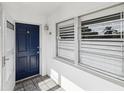 Entrance to unit 128 featuring a blue front door, white trim, and tiled entryway at 128 Brandy Wine Dr, Largo, FL 33771