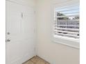 A view of the interior side of the front door and the shuttered window in the entry hall at 128 Brandy Wine Dr, Largo, FL 33771