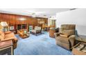 Cozy living room featuring wood paneling, comfortable seating, and natural light at 1301 62Nd S Ter, St Petersburg, FL 33705