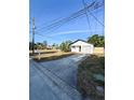 Inviting single-story home with a long drive, attached garage, lush landscape, and well-maintained lawn at 13018 Clay Ave, Largo, FL 33773