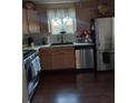 Well-equipped kitchen featuring stainless steel appliances, wooden cabinets, and tile backsplash at 13020 Lorna Pl, Tampa, FL 33618