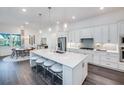 Bright kitchen with a large center island, white cabinetry, stainless steel appliances, and pendant lighting at 14727 Eagle Branch Dr, Nokomis, FL 34275