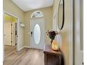 Inviting entryway featuring wood-look flooring and an oval glass accent in the front door for natural light at 1535 Crossvine Ct, Trinity, FL 34655