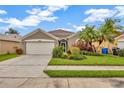 Charming single-story home featuring a well-manicured lawn, mature palm trees, and an attached two-car garage at 1535 Crossvine Ct, Trinity, FL 34655