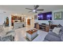 Spacious open-concept living room with a ceiling fan and seamless flow to the kitchen, ideal for modern living at 16704 Sunburst Lake St, Wimauma, FL 33598