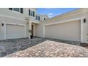 Spacious driveway with a two-car garage and beautiful landscaping provides ample parking and curb appeal at 18017 Ramble On Way, Land O Lakes, FL 34638